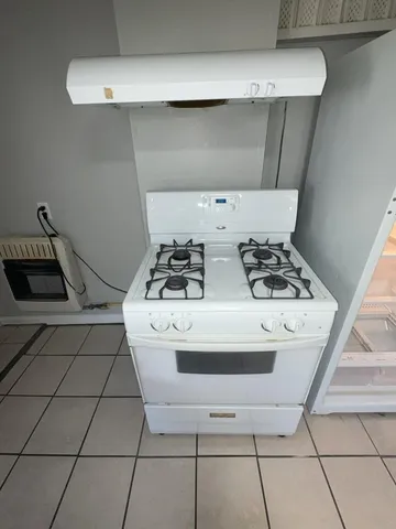 a white stove top oven sitting inside of a kitchen