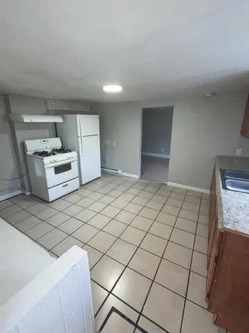 a kitchen with granite countertop a stove and a refrigerator