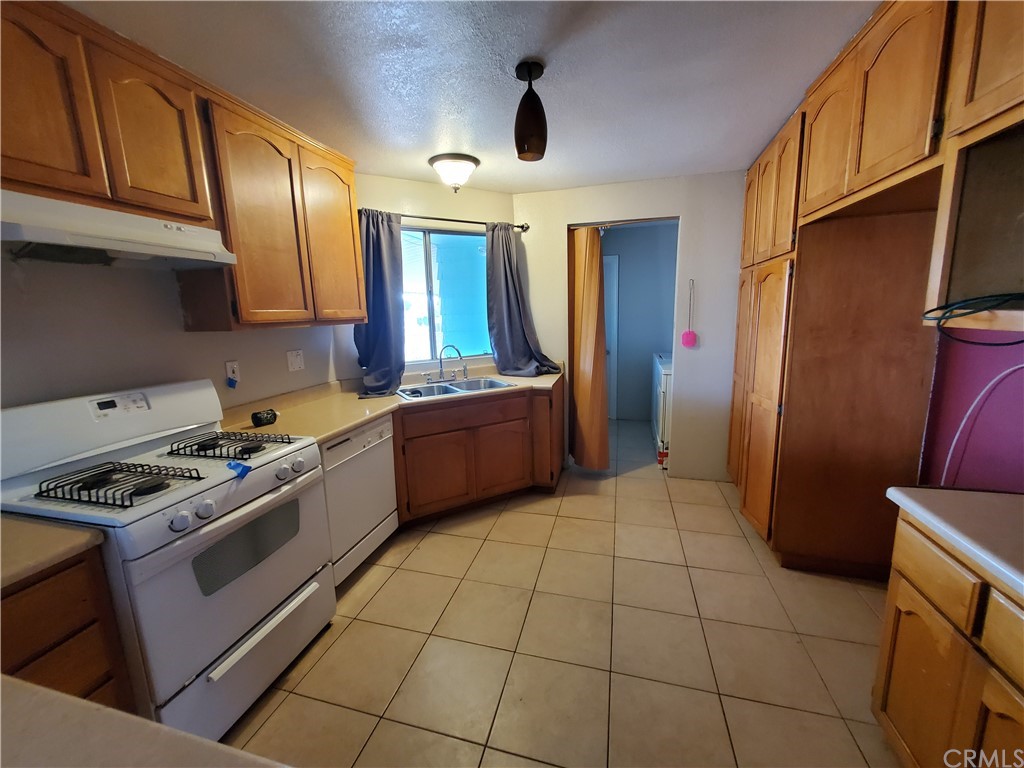 1685 Murrieta Road Perris, CA 92571 - Photo 9 of 19 a kitchen with stainless steel appliances granite countertop a stove a sink and a refrigerator