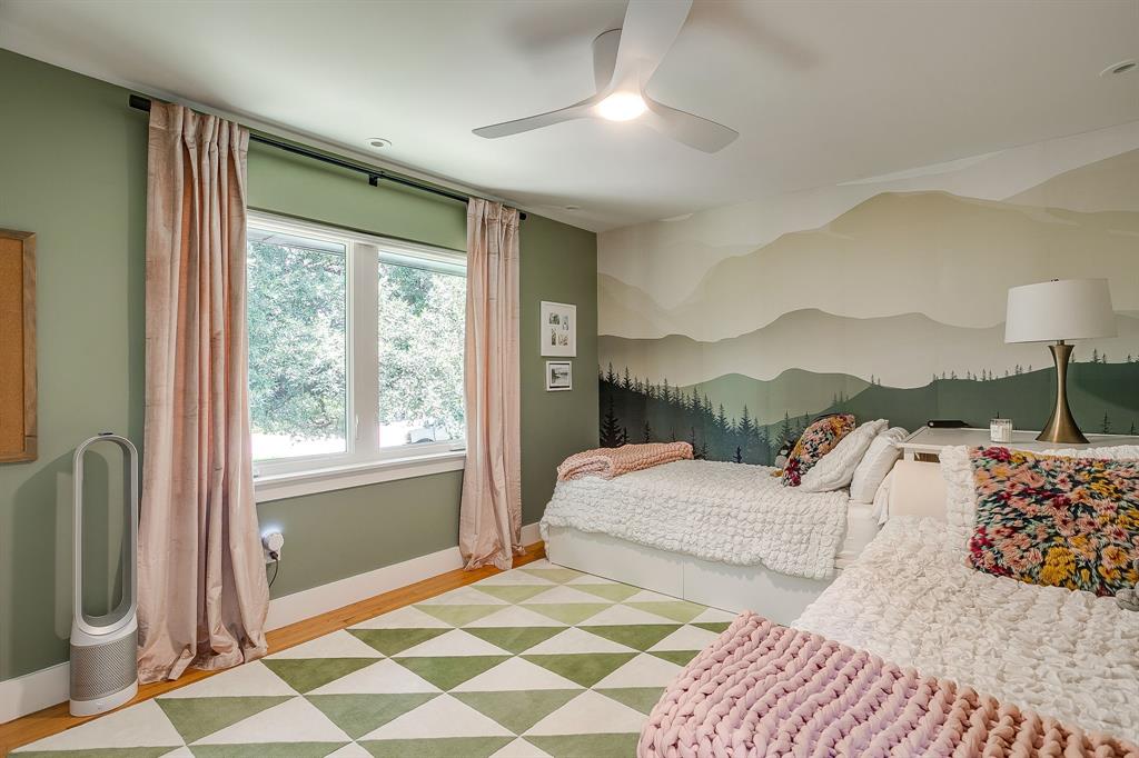 6700 Fortune Road Fort Worth, TX 76116 - Photo 34 of 40 Bright room featuring a window with natural light, a ceiling fan, a decorative wall mural, and light wood-finish flooring