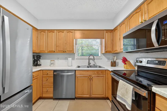 a kitchen with stainless steel appliances a sink stove and cabinets