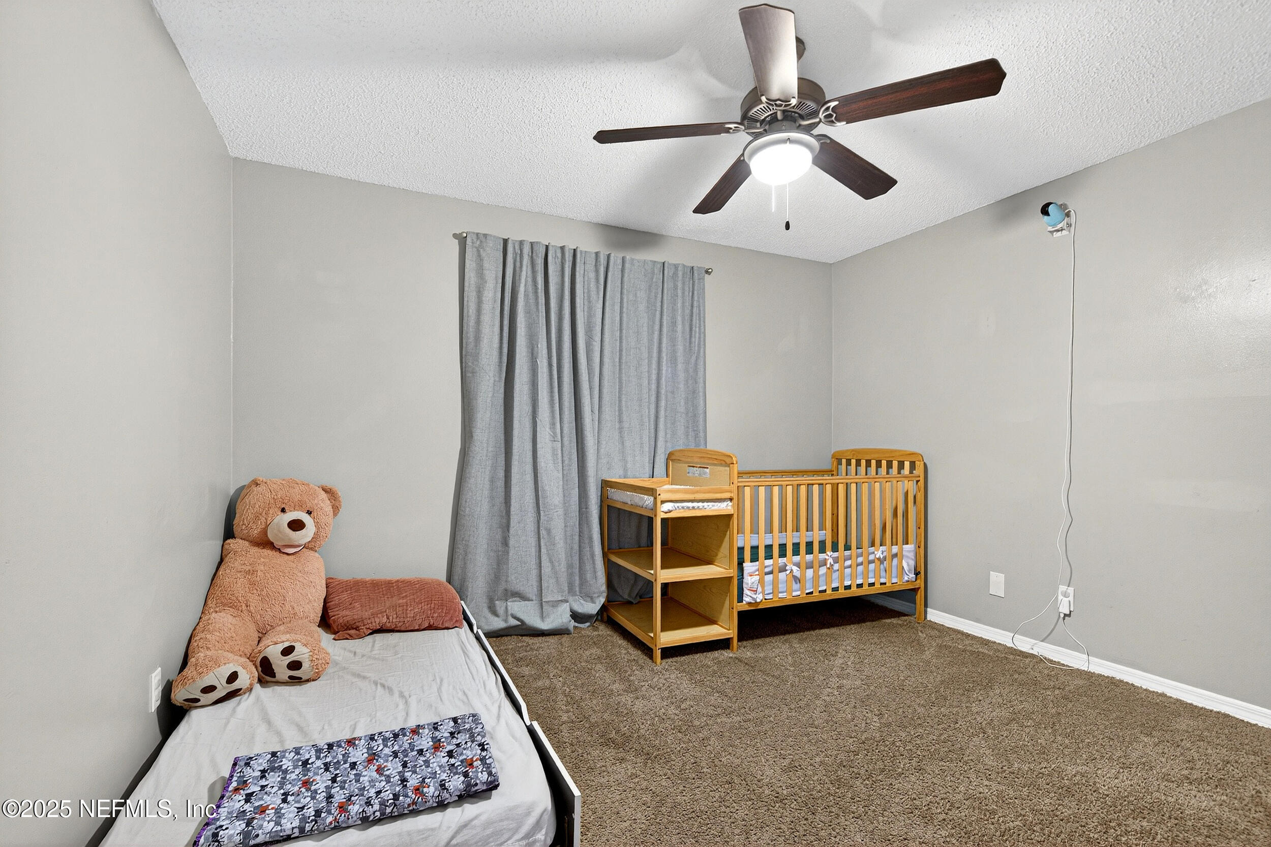 13808 Spanish Point Drive Jacksonville, FL 32225 - Photo 18 of 25 a bedroom with a bed and a chandelier