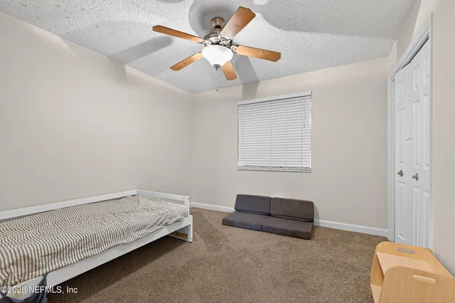 a living room with furniture and a ceiling fan