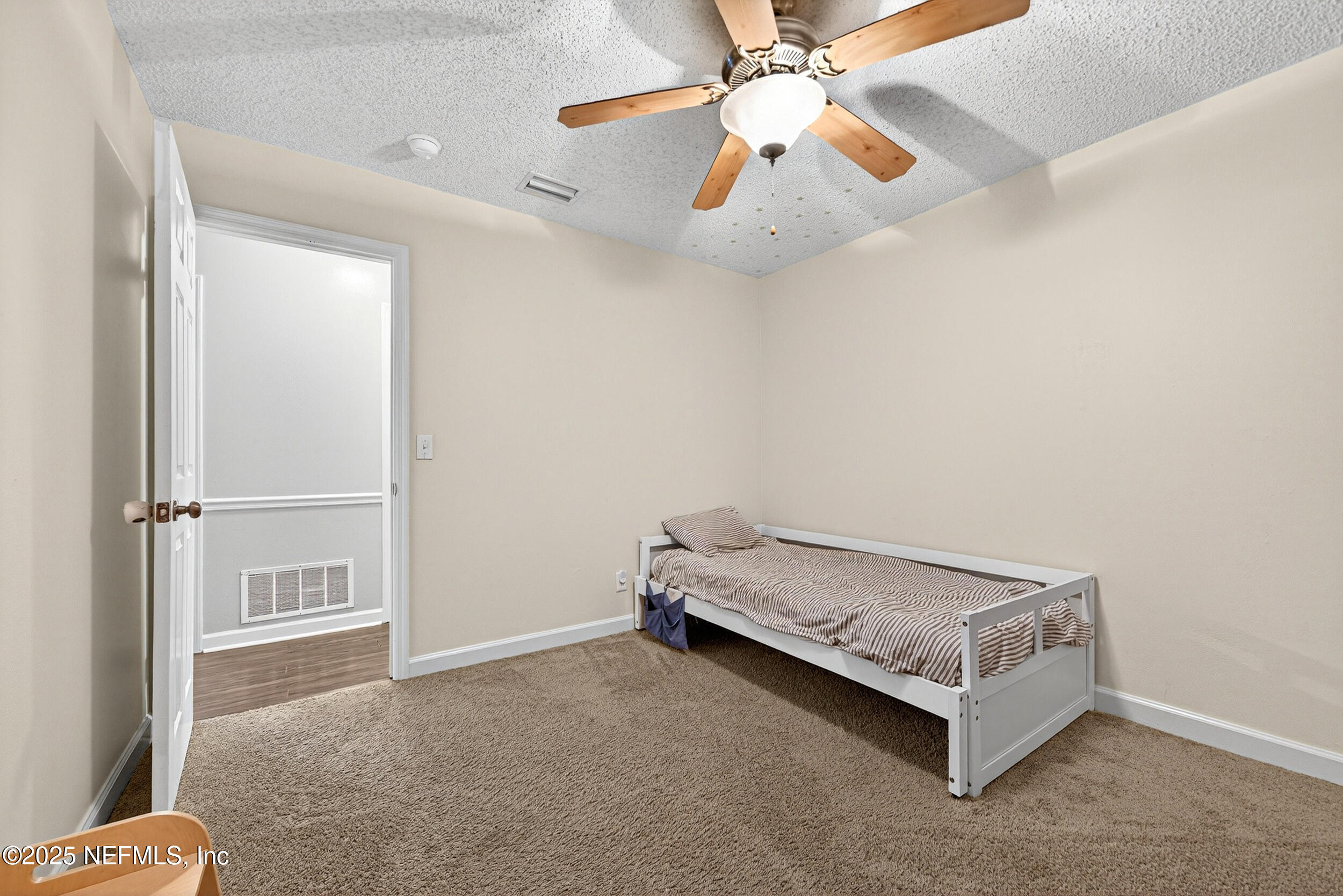 13808 Spanish Point Drive Jacksonville, FL 32225 - Photo 22 of 25 a room with a bed and a chandelier fan