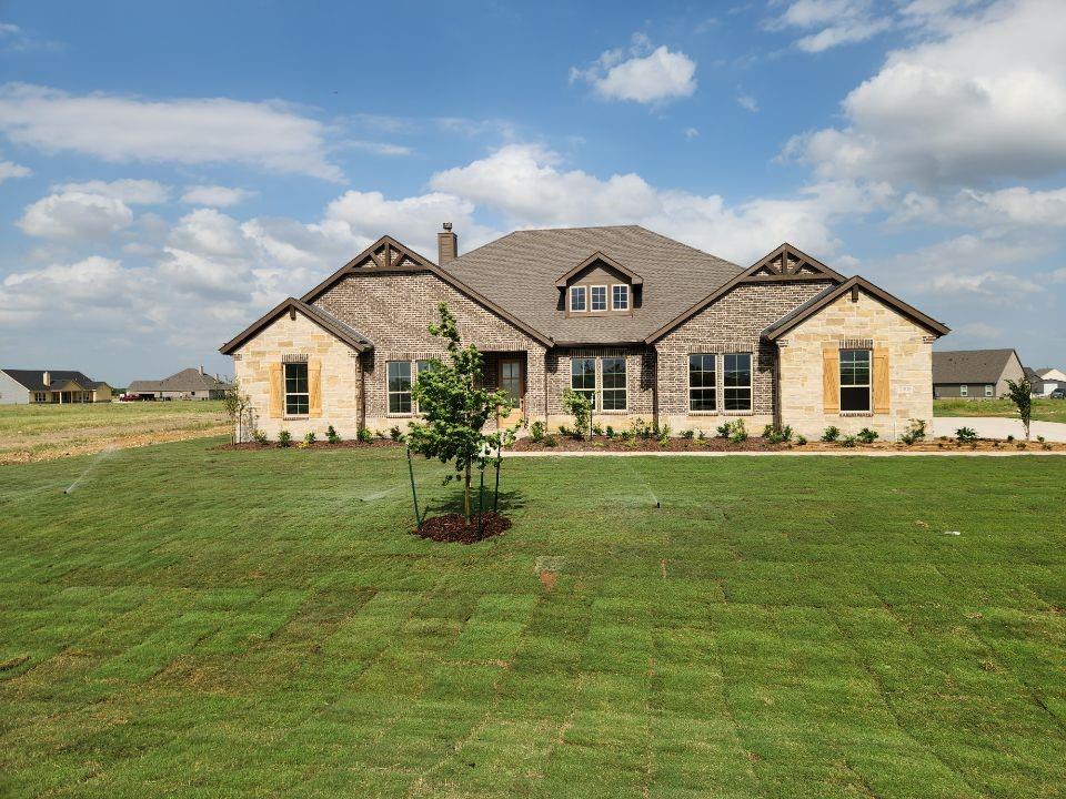 2408 Quartz Street Krum, TX 76249 - Photo 1 of 16 a view of a white house with a big yard and potted plants