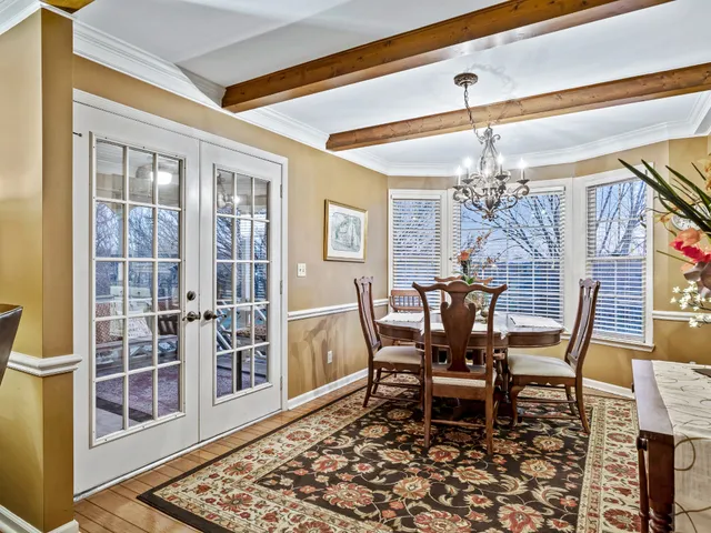 a dining room with furniture a chandelier and wooden floor