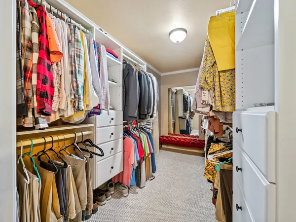 a view of walk in closet with clothes and shoes
