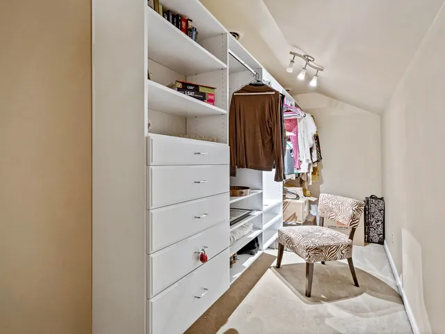a view of walk in closet with clothes and shoes