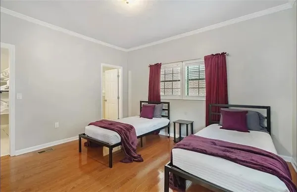 a bedroom with two beds and a potted plant