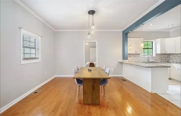 a bathroom with a granite countertop sink and dishwasher with wooden floor
