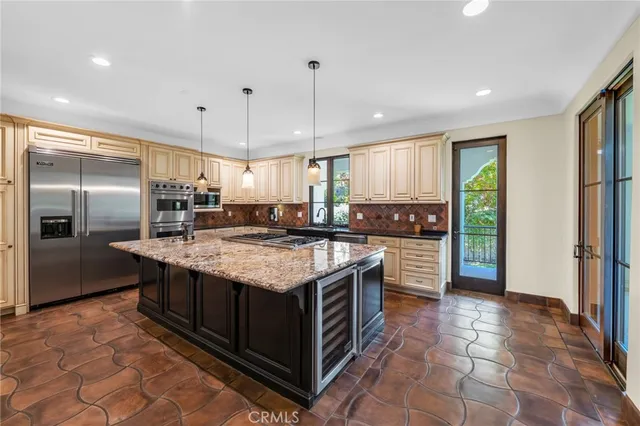 a kitchen with kitchen island granite countertop a sink stainless steel appliances and cabinets