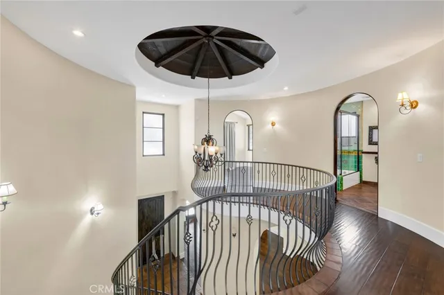 a view of empty room with wooden floor and kitchen