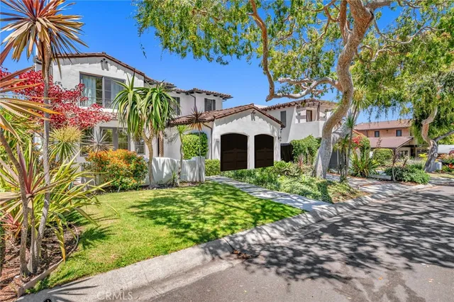 a front view of a house with a yard and potted plants
