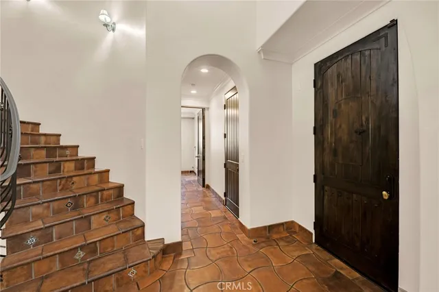 an empty room with wooden floor fireplace and windows