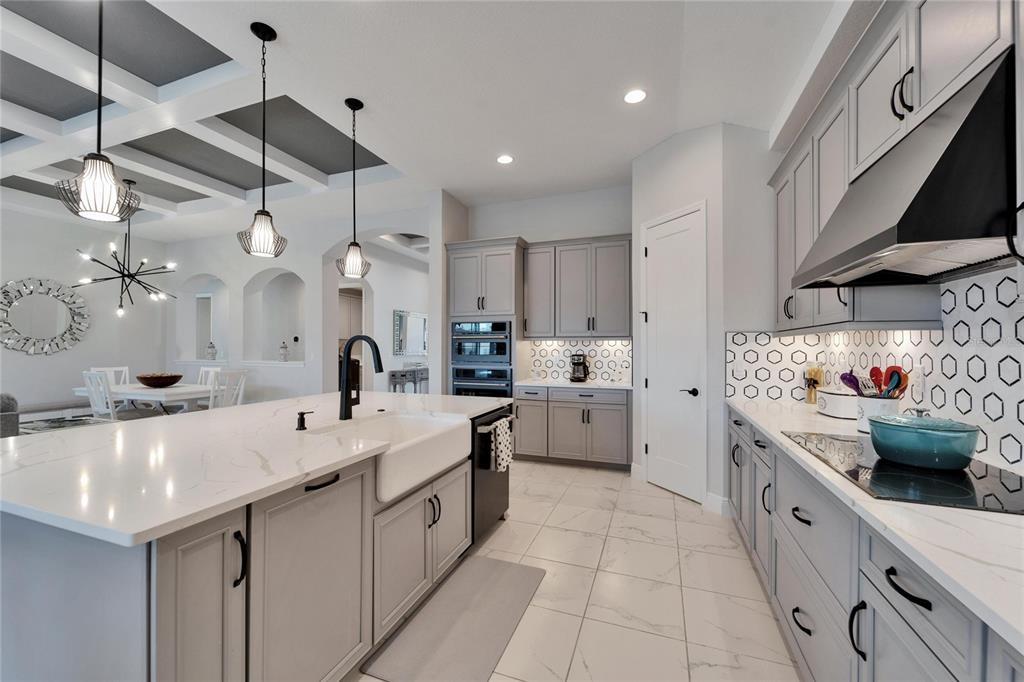 9152 Warm Spgs Circle Parrish, FL 34219 - Photo 6 of 38 a large white kitchen with a large kitchen island white cabinets and stainless steel appliances