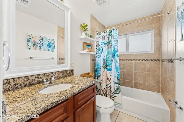 a bathroom with a granite countertop sink a toilet and bathtub