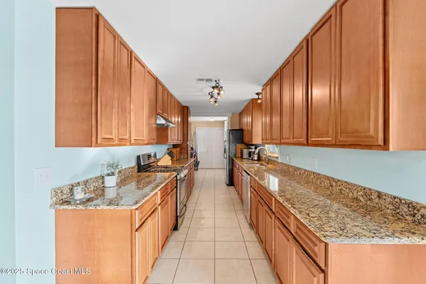 a large kitchen with stainless steel appliances granite countertop a sink and cabinets