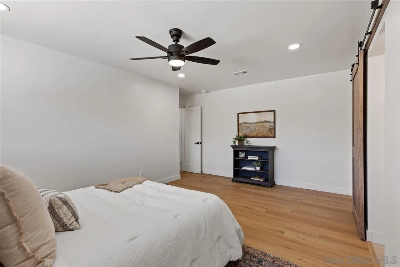 30118 Miller Road Valley Center, CA 92082 - Photo 19 of 75 a bedroom with a large bed and a flat tv screen on dresser
