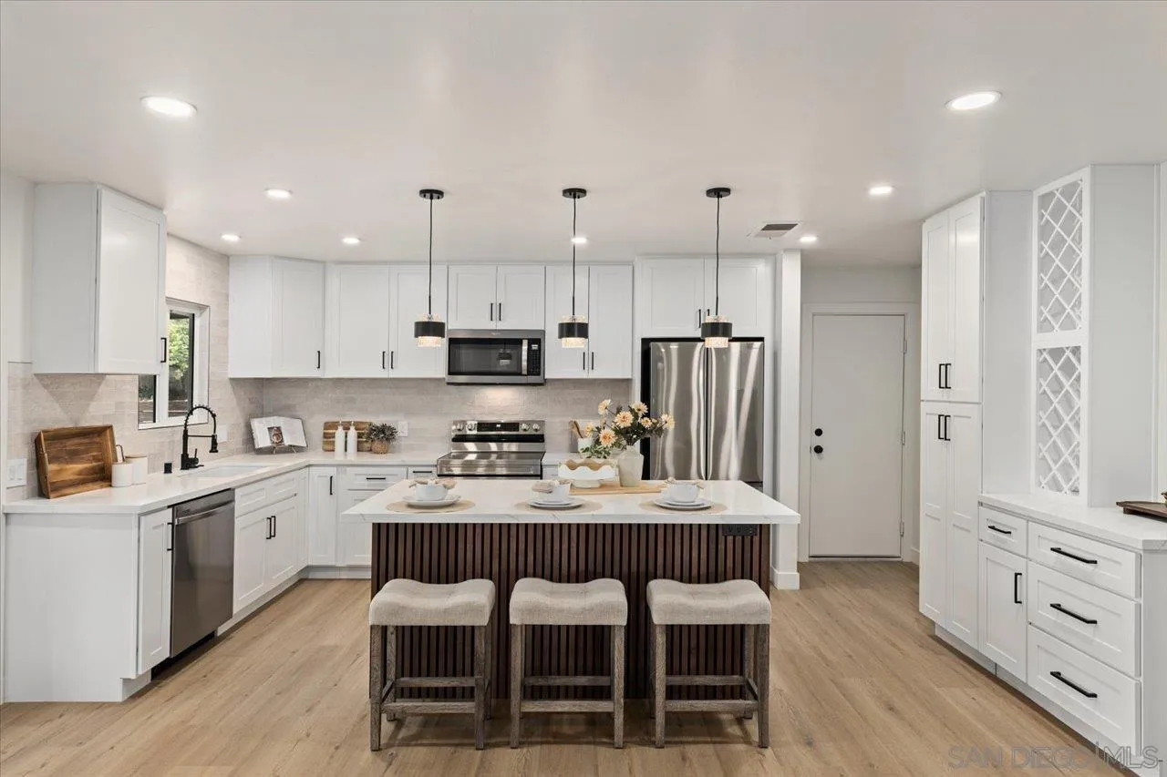 30118 Miller Road Valley Center, CA 92082 - Photo 7 of 75 a kitchen with stainless steel appliances kitchen island granite countertop a table chairs sink refrigerator and cabinets