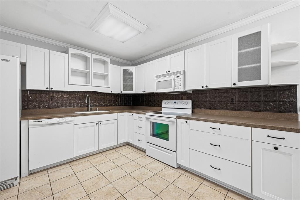 6878 Southwest 36th Street Lake Butler, FL 32054 - Photo 13 of 30 a kitchen with granite countertop white cabinets and white appliances