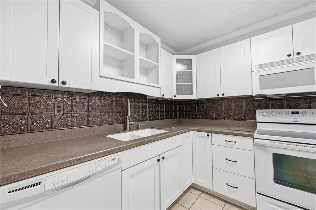 6878 Southwest 36th Street Lake Butler, FL 32054 - Photo 15 of 30 a kitchen with granite countertop white cabinets and white stainless steel appliances