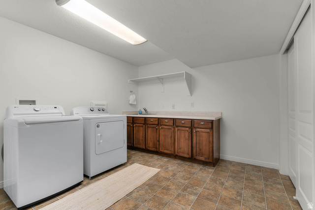 439 East 13540 South Draper, UT 84020 - Photo 28 of 46 Functional laundry area featuring white walls, tiled flooring, wood-finish cabinetry, a light-toned countertop, and built-in shelving