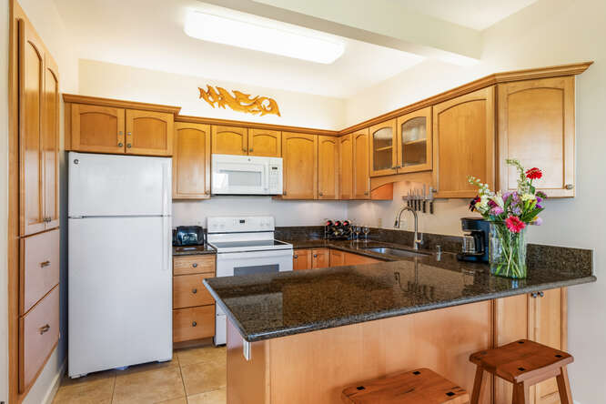 1901 Poipu Road, Unit 311 Koloa, HI 96756 - Photo 24 of 29 a kitchen with stainless steel appliances granite countertop a sink refrigerator and cabinets