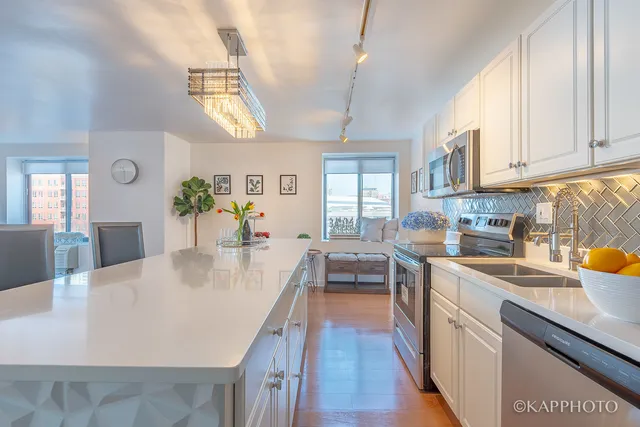a large kitchen with kitchen island a stove a sink a dining table and chairs
