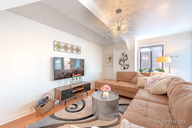 a living room with furniture and a chandelier