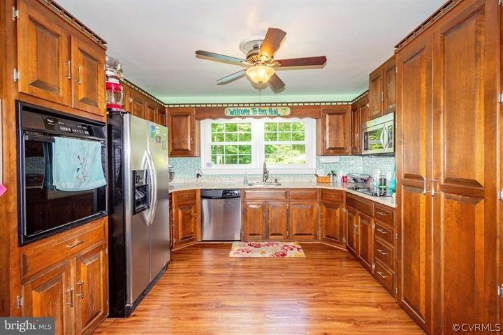 2400 Butler Road Beaverdam, VA 23015 - Photo 6 of 46 a kitchen with stainless steel appliances granite countertop a refrigerator a sink dishwasher and wooden cabinets with wooden floor