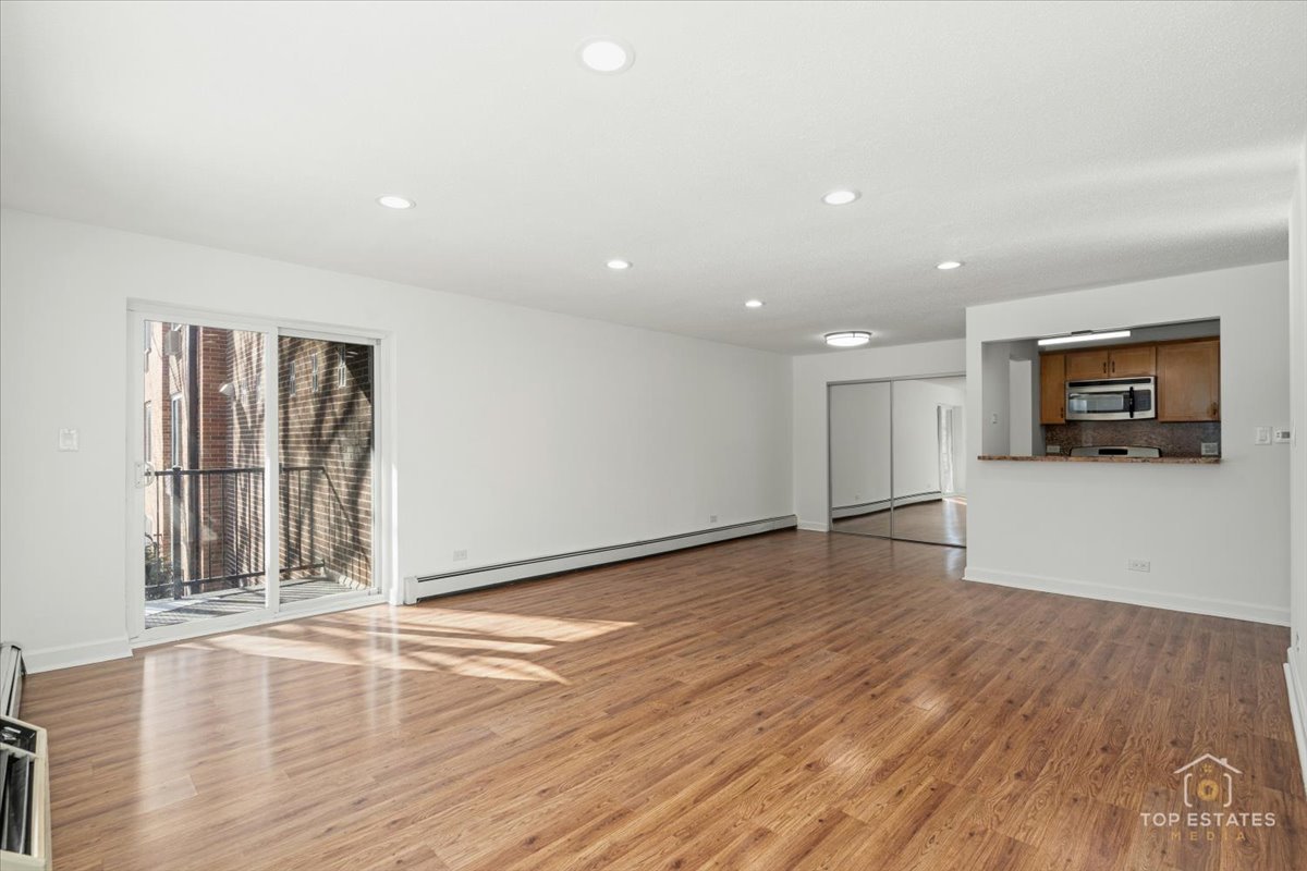 1107 South Old Wilke Road, Unit 208 Rolling Meadows, IL 60005 - Photo 12 of 43 a view of empty room with wooden floor and fireplace