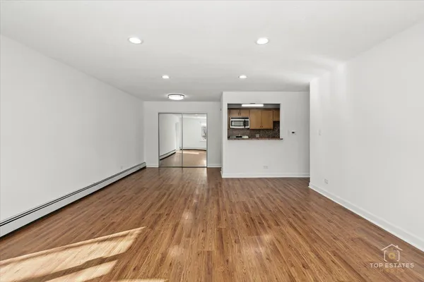a view of a room with wooden floor and bathroom