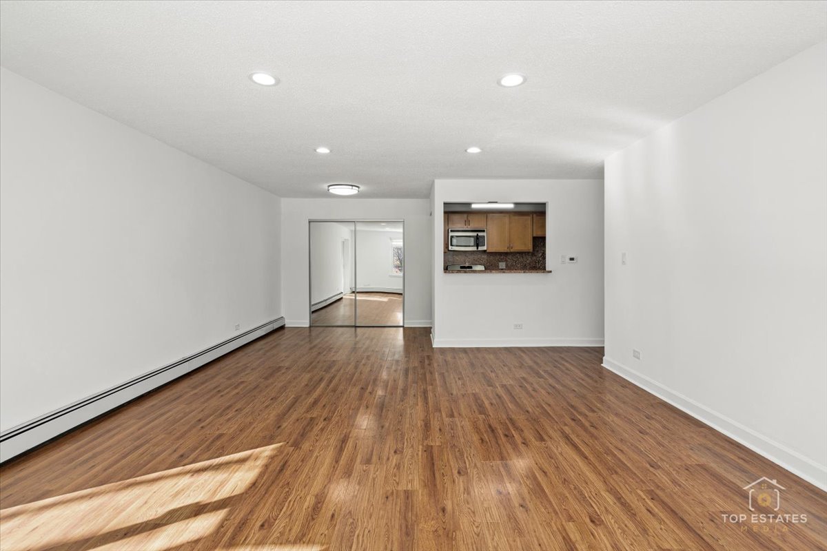 1107 South Old Wilke Road, Unit 208 Rolling Meadows, IL 60005 - Photo 13 of 43 a view of a big room with wooden floor and windows