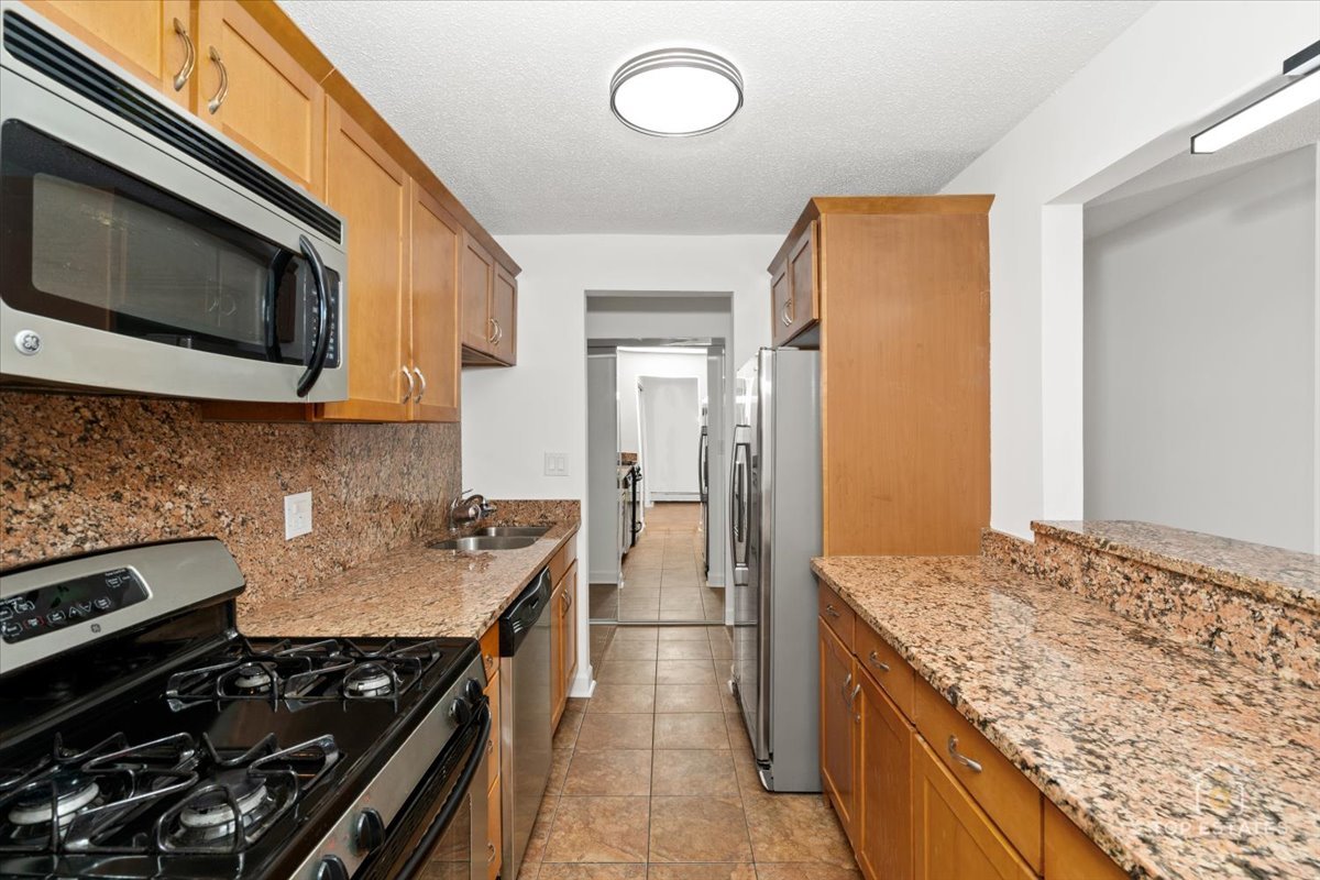 1107 South Old Wilke Road, Unit 208 Rolling Meadows, IL 60005 - Photo 17 of 43 a kitchen with a stove and a microwave