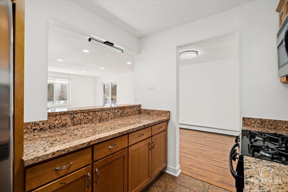 1107 South Old Wilke Road, Unit 208 Rolling Meadows, IL 60005 - Photo 20 of 43 a view of a kitchen counter space and wooden floor