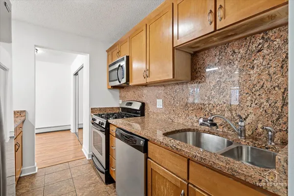 a bathroom with a granite countertop toilet sink and mirror