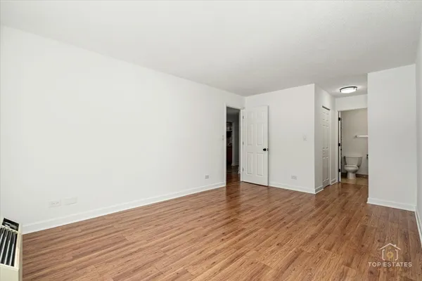 an empty room with wooden floor and closet