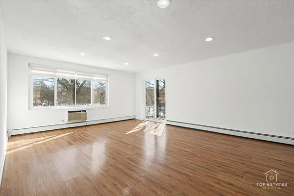 a view of empty room with wooden floor and fireplace