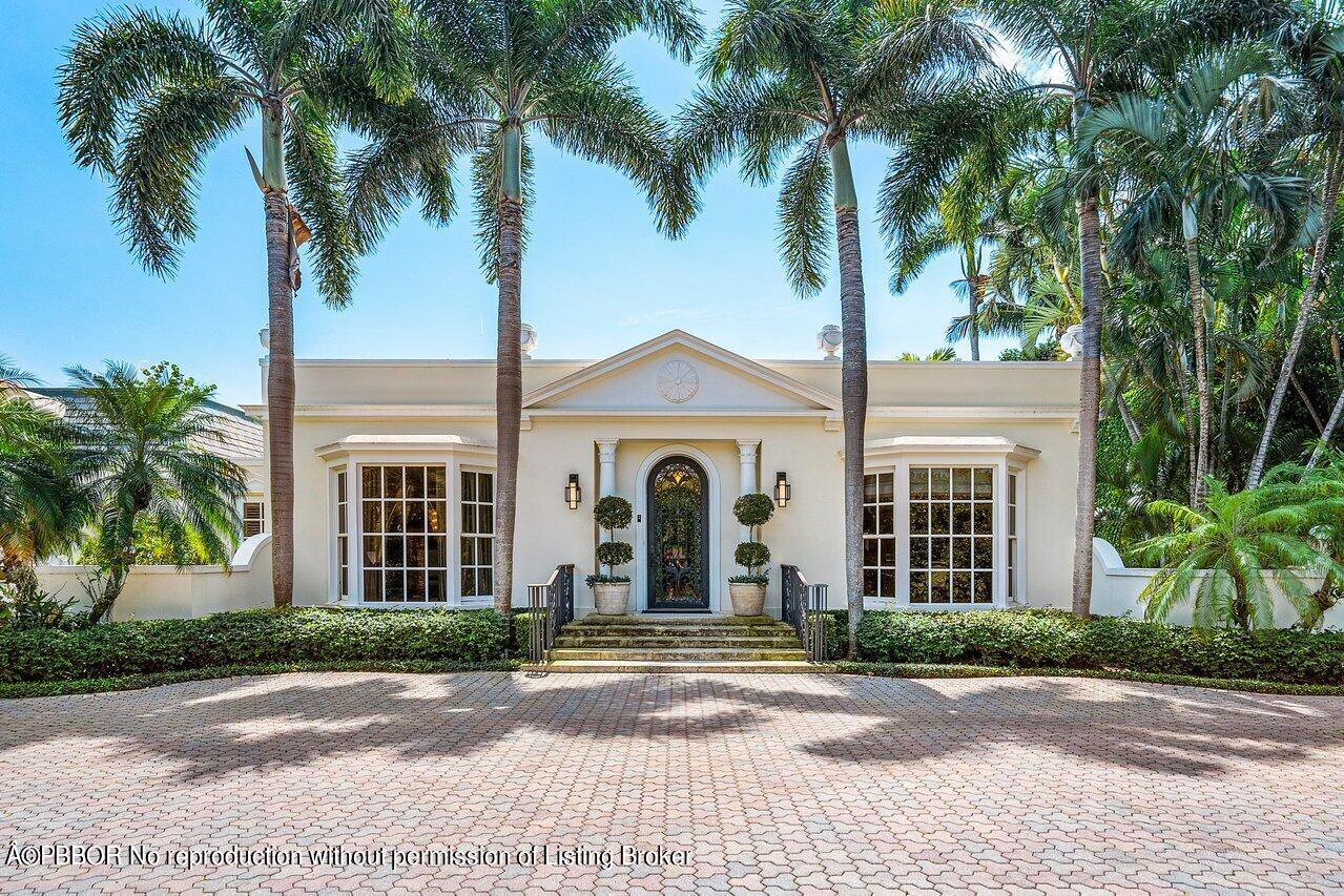 168 Kings Road Palm Beach, FL 33480 - Photo 2 of 30 a view of a brick house with a large windows and palm trees
