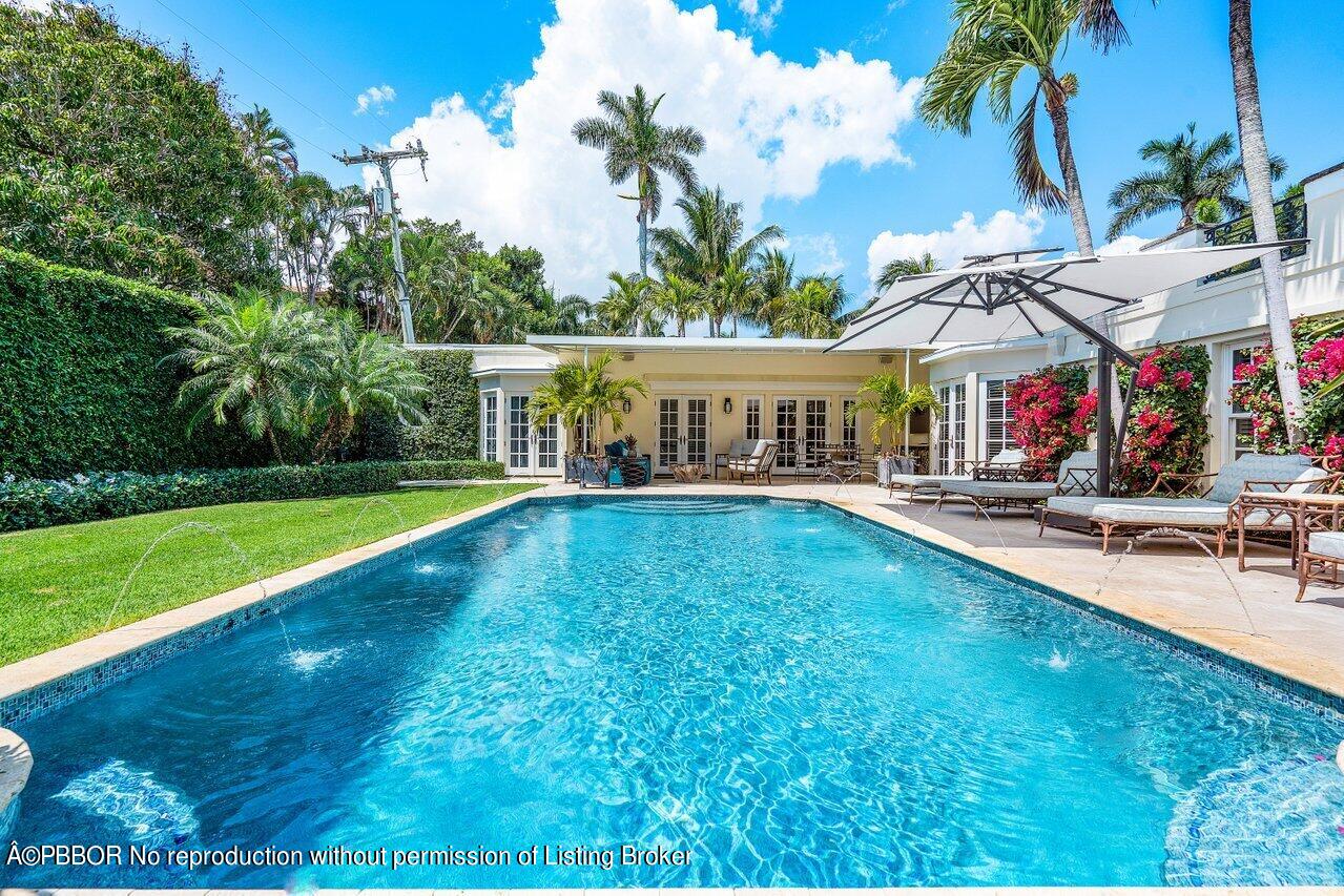168 Kings Road Palm Beach, FL 33480 - Photo 27 of 30 a view of a swimming pool with lawn chairs and plants
