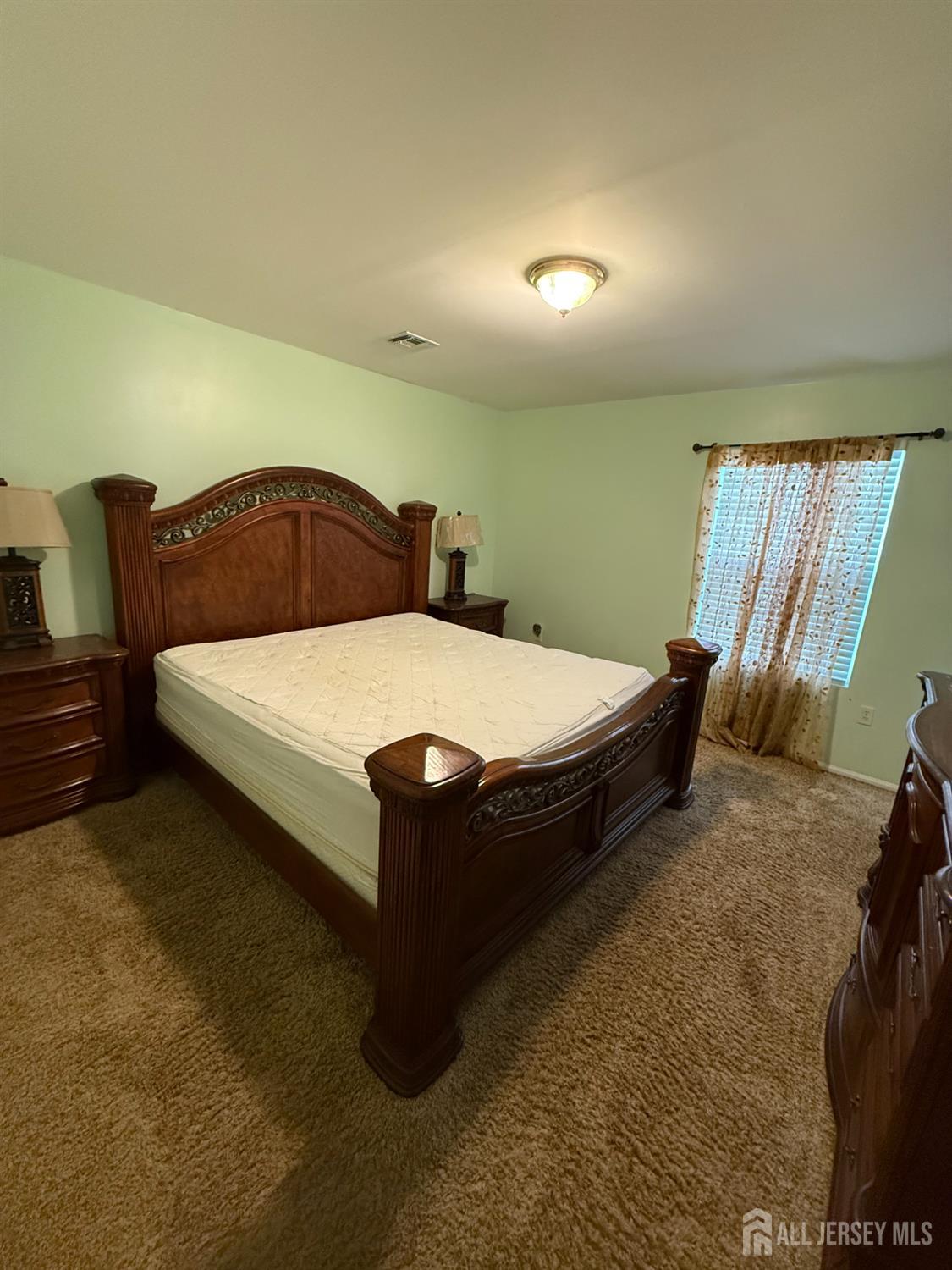 31 Beverly Street, Unit 2ND F Carteret, NJ 07008 - Photo 9 of 20 a bed sitting in a room next to a lamp