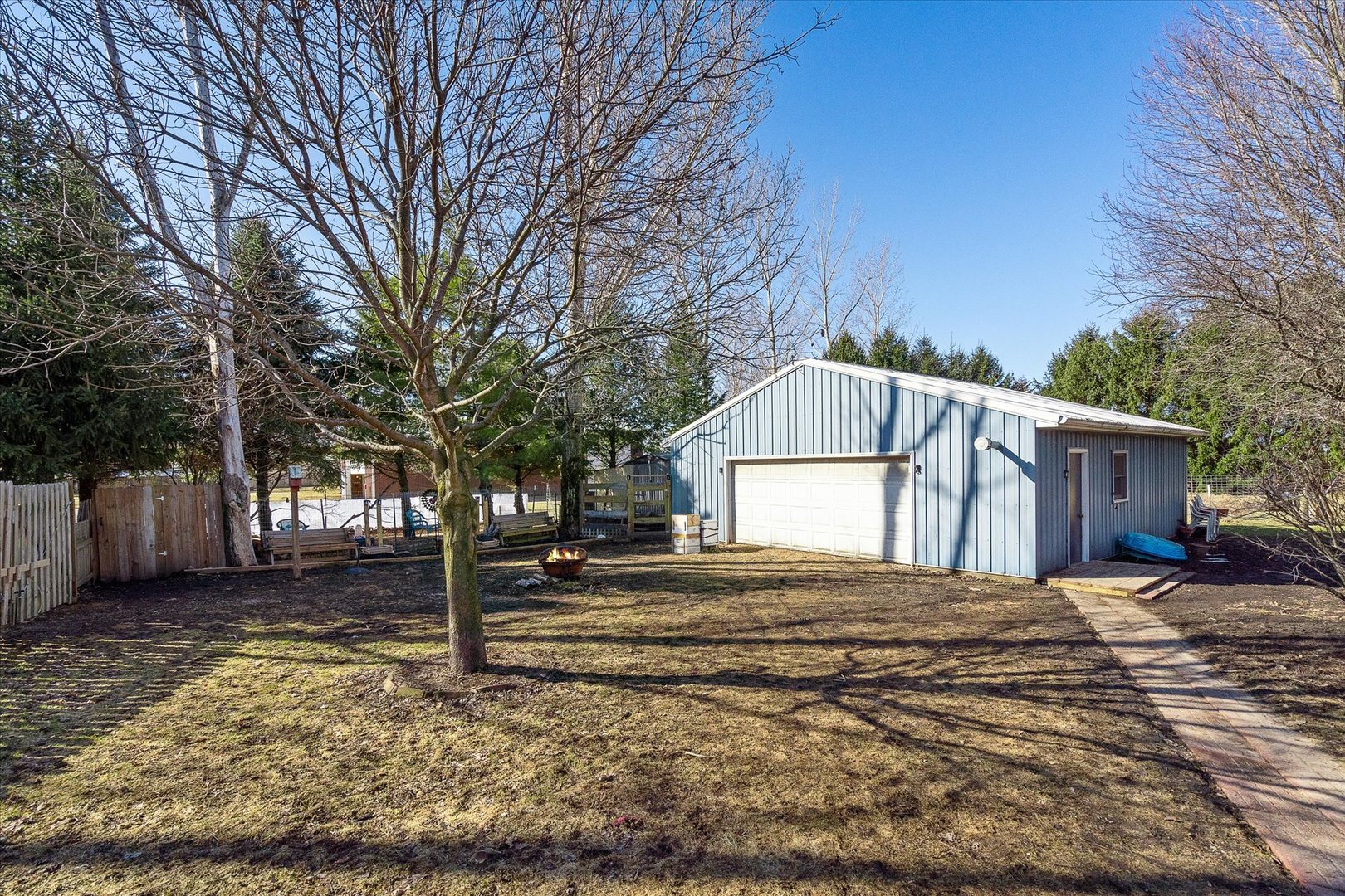 4461 Highway 23 Leland, IL 60531 - Photo 22 of 28 a backyard of a house with wooden fence and large trees