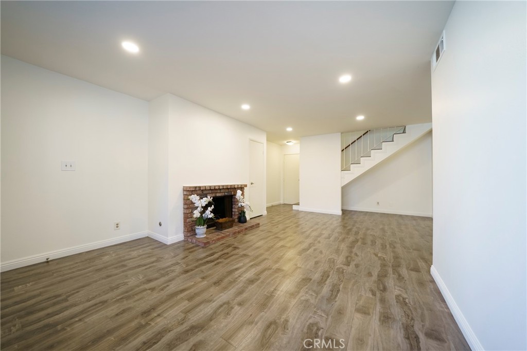 10663 Bell Street Stanton, CA 90680 - Photo 8 of 38 an empty room with wooden floor and fireplace