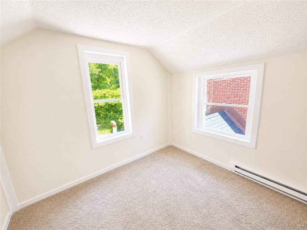 508 Riegel Street Bethlehem, PA 18018 - Photo 7 of 9 A well-lit bedroom with fresh carpet flooring and a view of the surrounding trees.