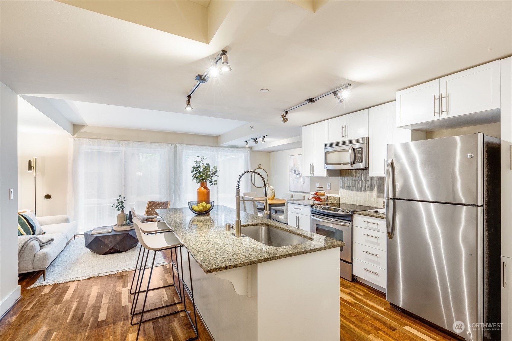 699 John Street, Unit 209 Seattle, WA 98109 - Photo 13 of 28 a kitchen with stainless steel appliances granite countertop a refrigerator a oven a sink dishwasher and white cabinets with wooden floor