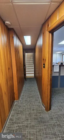 a view of hallway with stairs and wooden floor