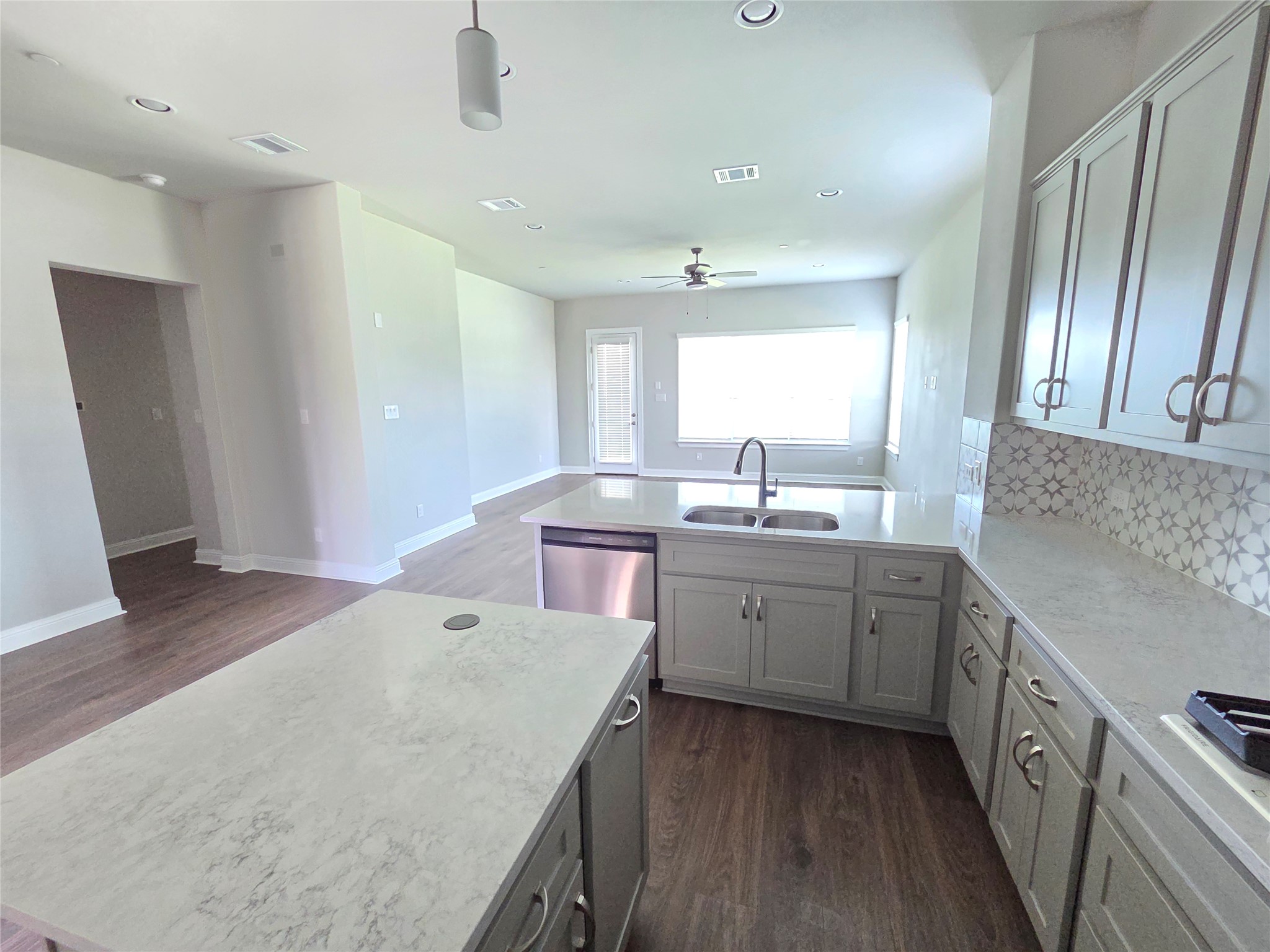600 C-Bar Ranch Trail, Unit 121 Cedar Park, TX 78613 - Photo 11 of 32 A contemporary kitchen features an island and ample counter space, flowing seamlessly into a well-lit living area.