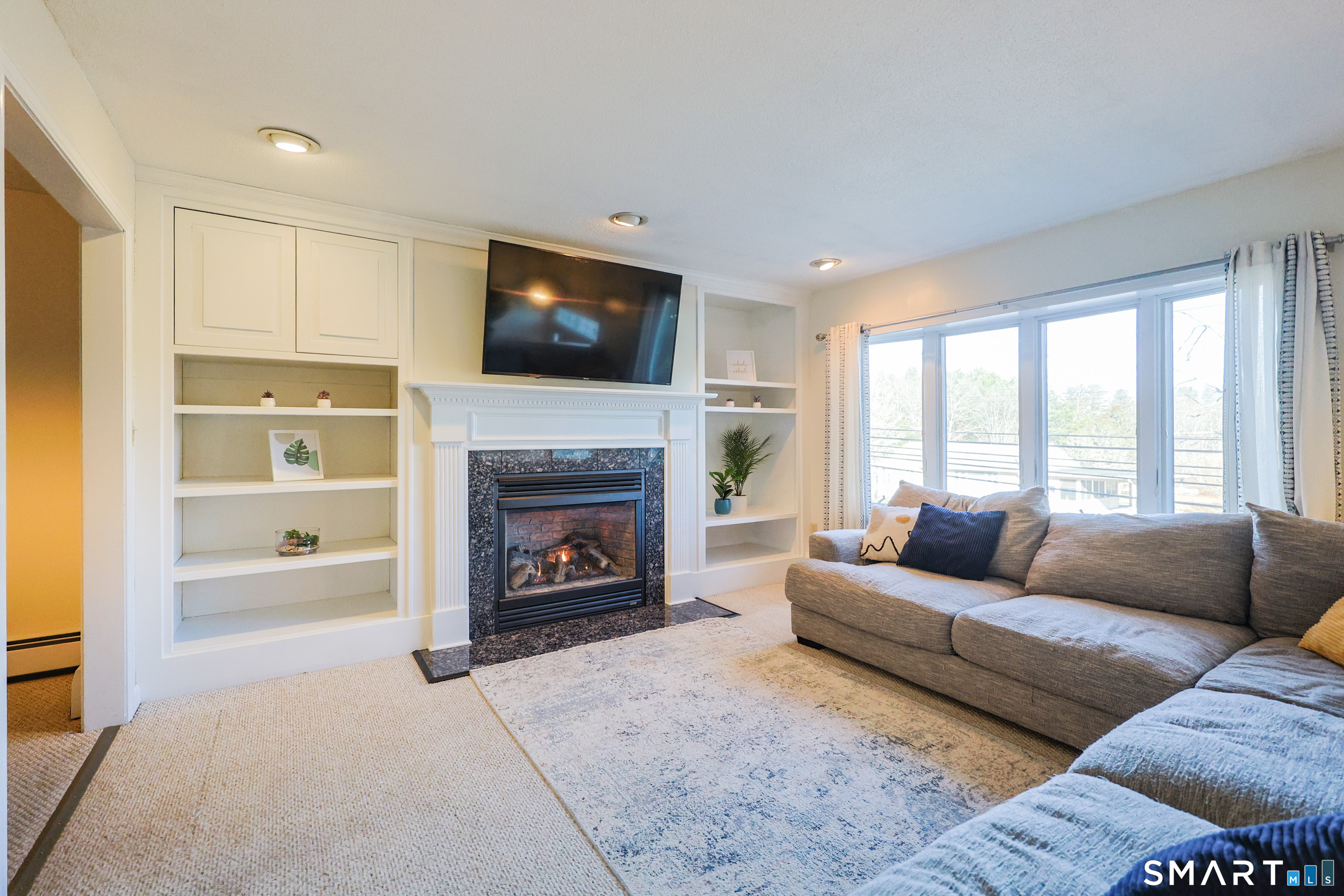 80 Sabin Street Putnam, CT 06260 - Photo 2 of 26 a living room with furniture a flat screen tv and a fireplace