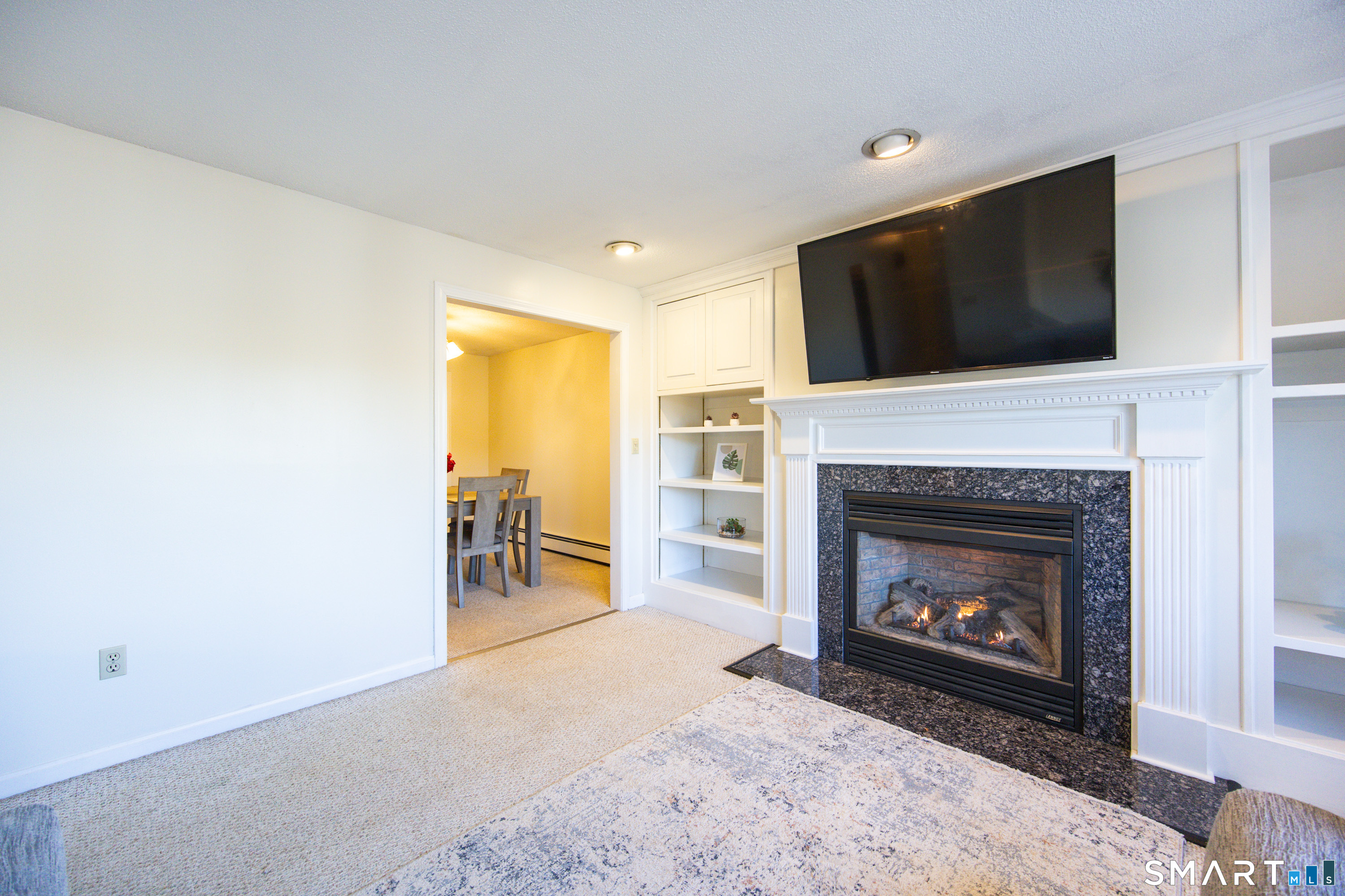 80 Sabin Street Putnam, CT 06260 - Photo 3 of 26 a living room with a fireplace a flat screen tv and a fireplace