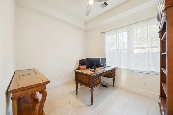 a view of a workspace with furniture and a window